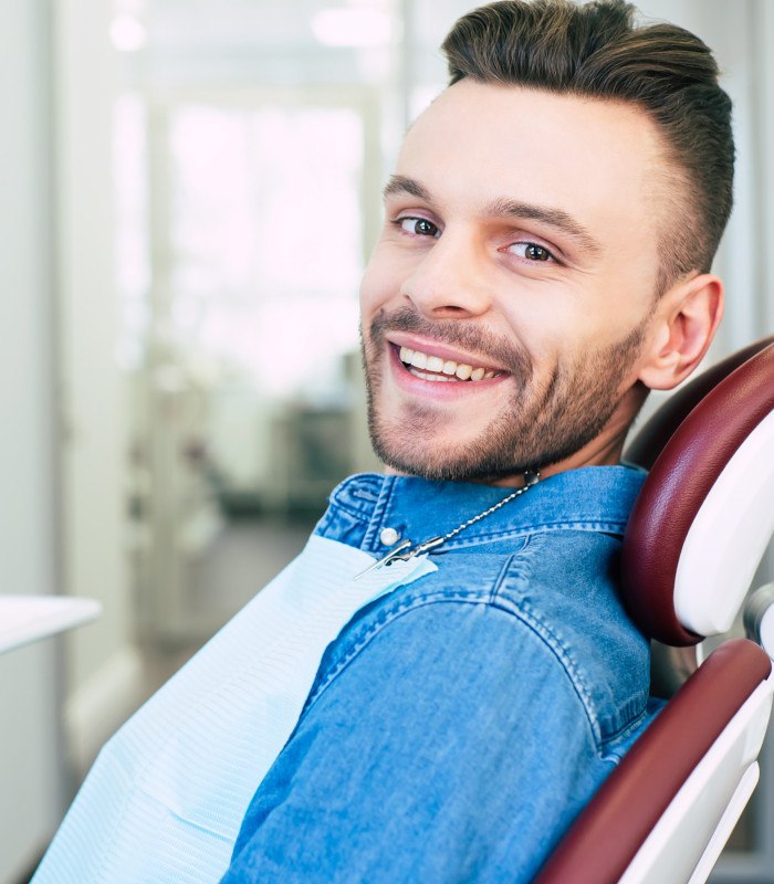 Man discussing the cost of treating dental emergencies with dental team member